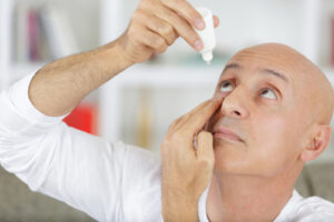 man using eye drops for dry eyes