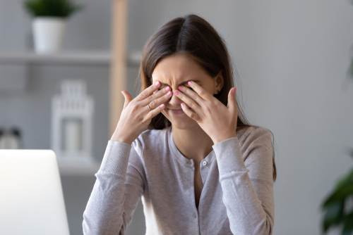 Young woman suffering from dry eyes