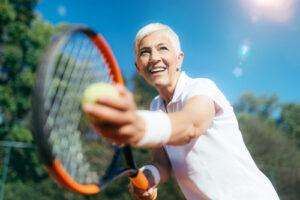 older person playing tennis