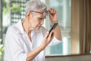 Lifting up glasses to look at phone