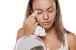 woman wiping her eyelid with a cloth