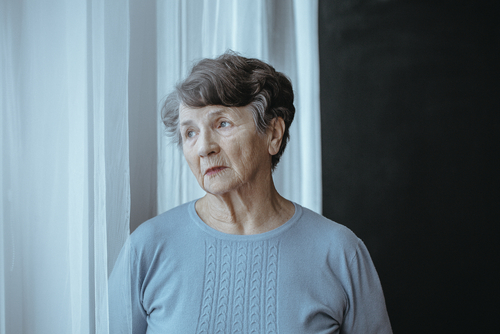 Older woman with cataracts looking out a window